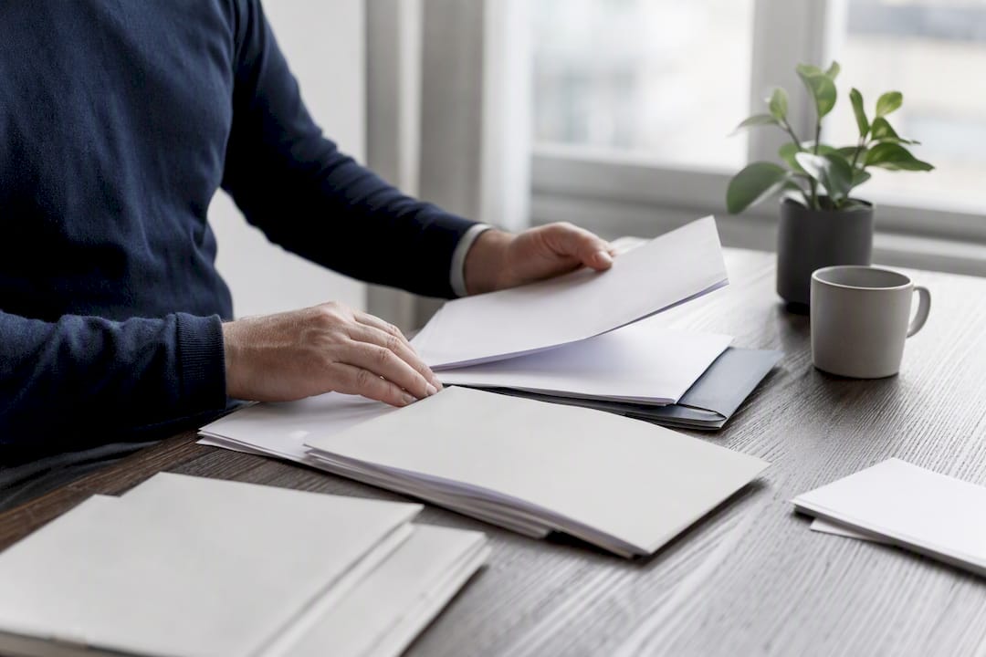Mains organisant des documents d'audit sur un bureau