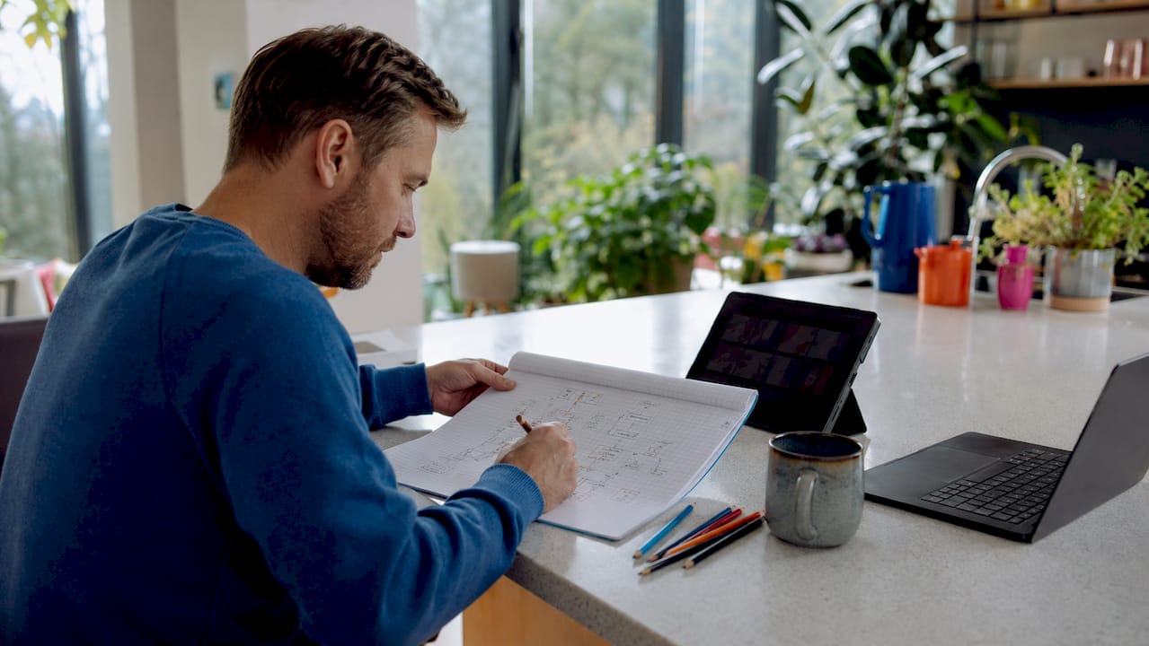 Hands typing notes on AI tool design in home office