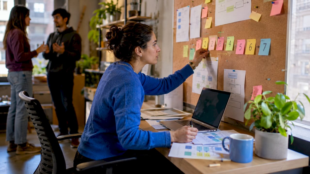 Engineer arranging AI agent workflow steps on whiteboard