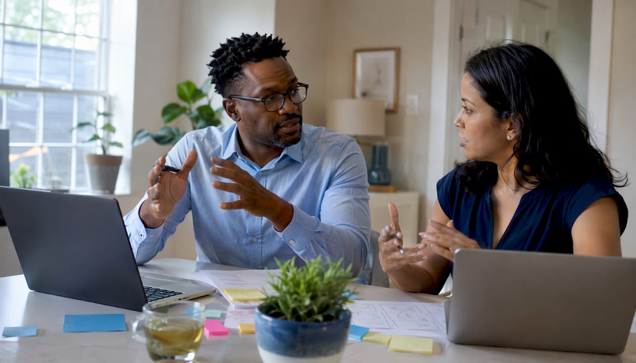 Two colleagues discussing AI load balancing challenges