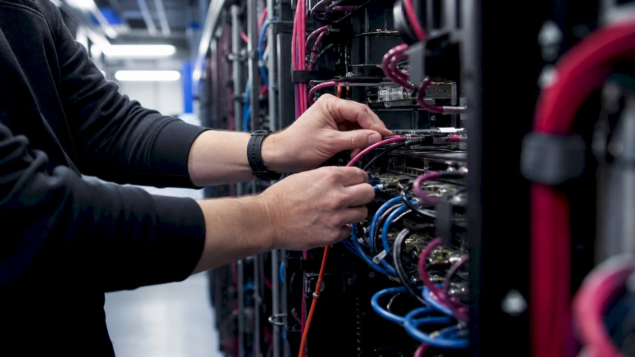 Hands wiring cables in enterprise data center