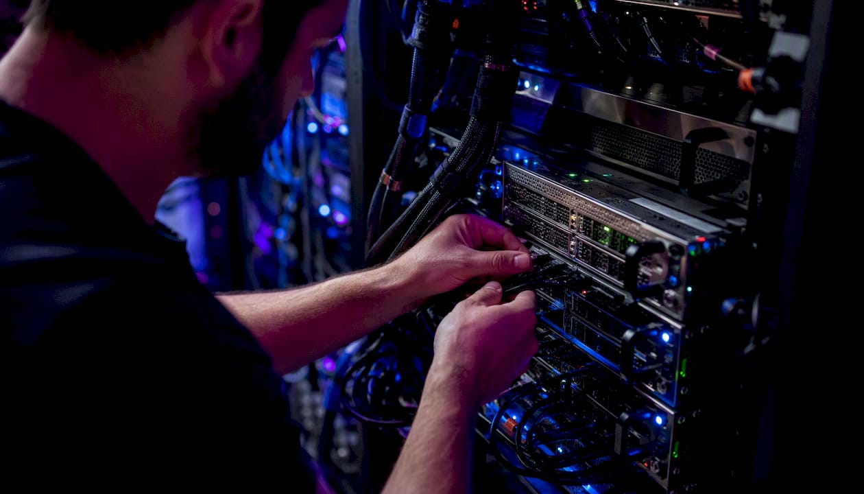 Technician connecting cables in AI server rack