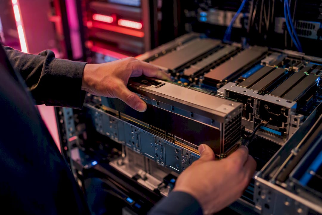 Hands installing GPU module in server