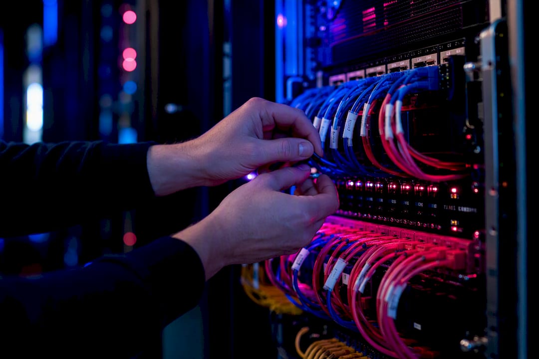 Hands managing network cables in AI data center