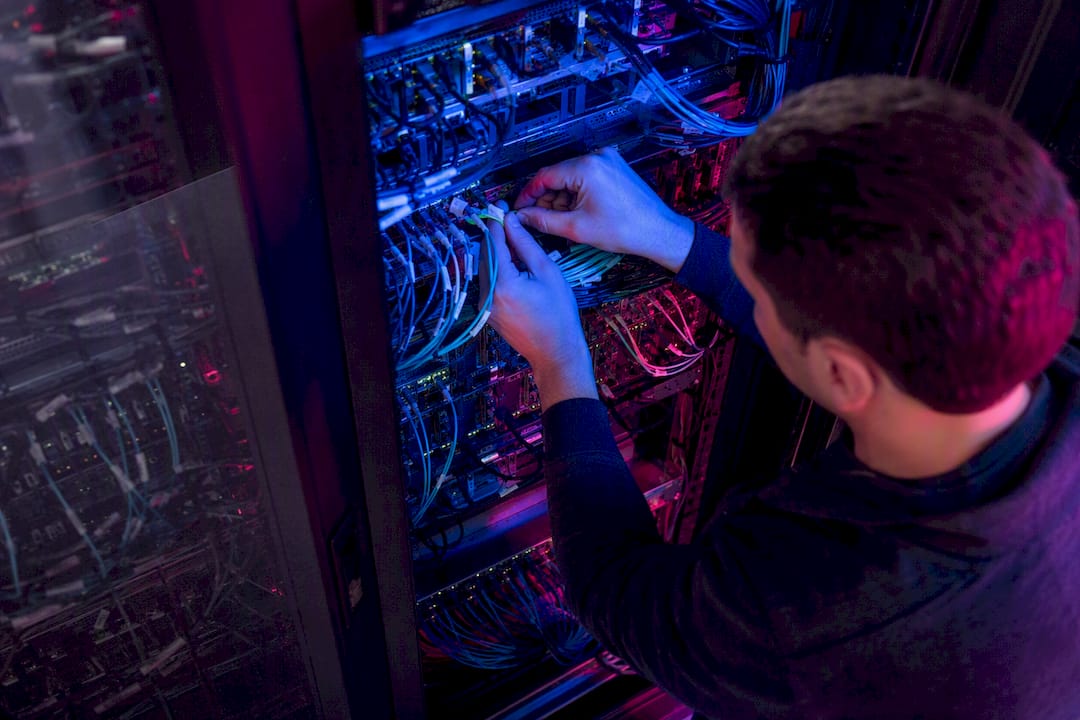 Technician connecting cables in AI server rack