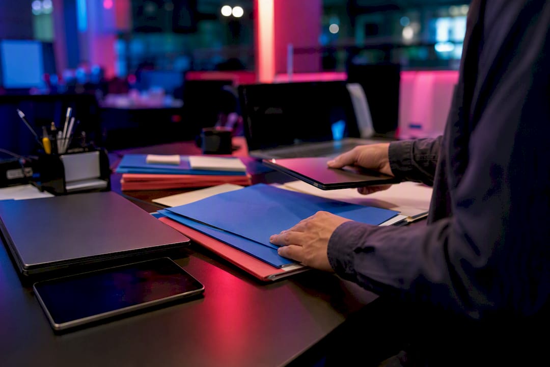 Hands arranging audit materials on tech desk
