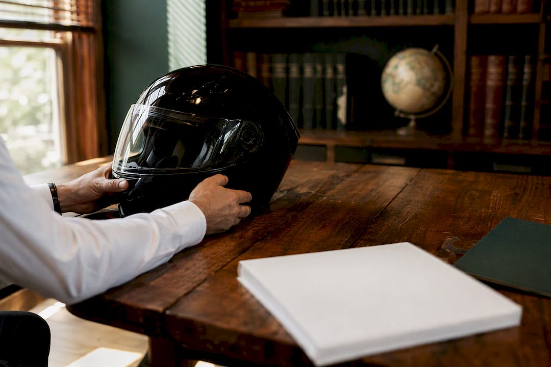 Hands adjusting motorcycle helmet on legal desk