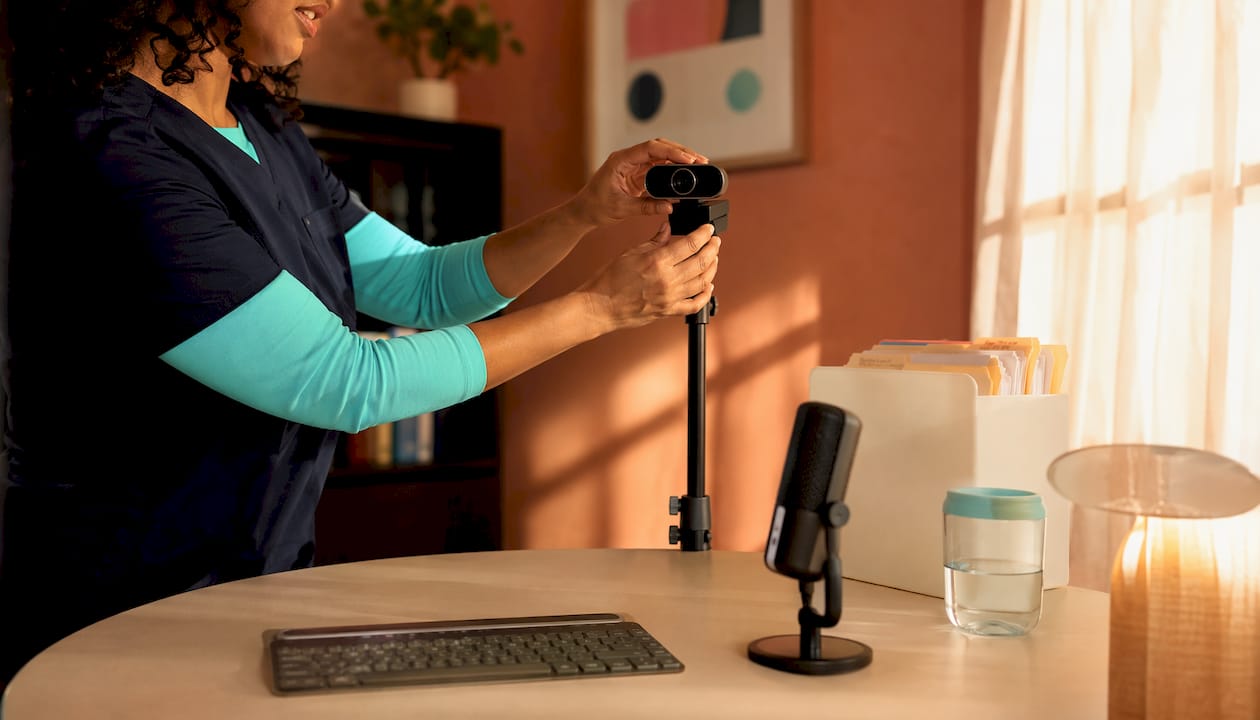 Clinician adjusting professional webcam hardware