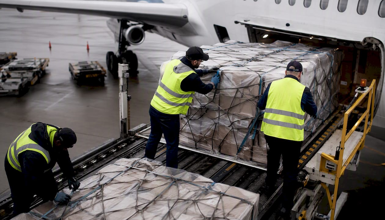 Hands securing medical supply pallets for air freight