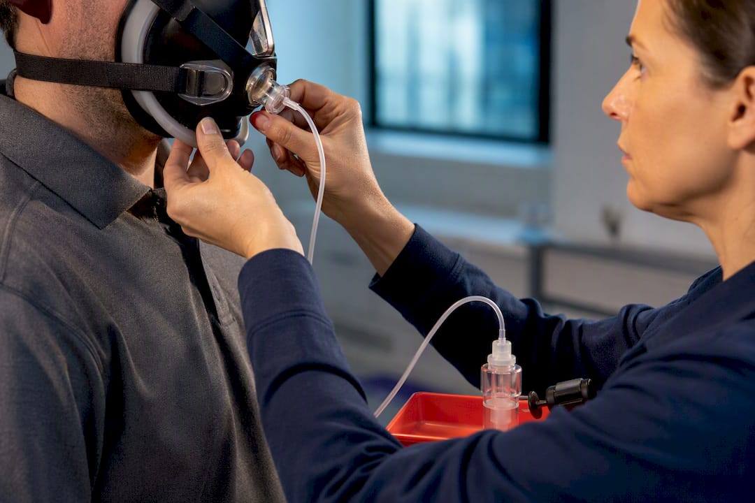 Technician adjusting respirator during fit test