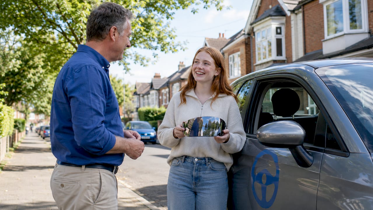 Driving instructor with learner beside car in Bletchley