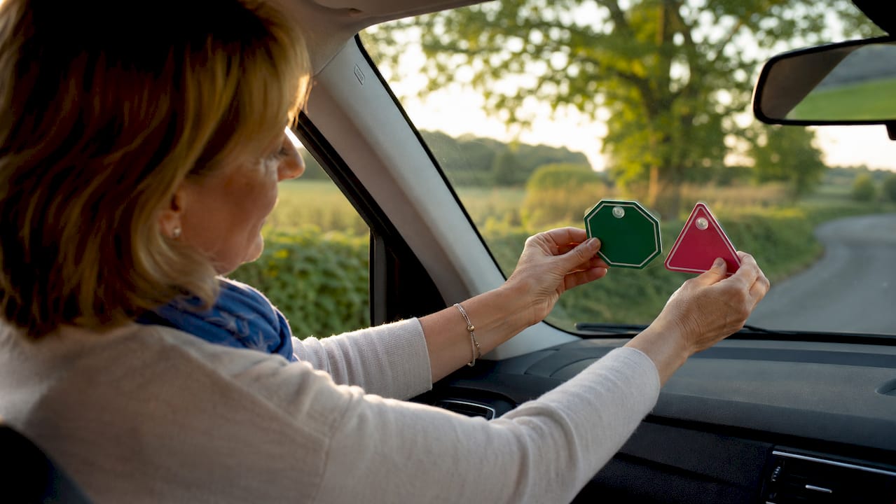 Hands attaching ADI and PDI badges to car windscreen