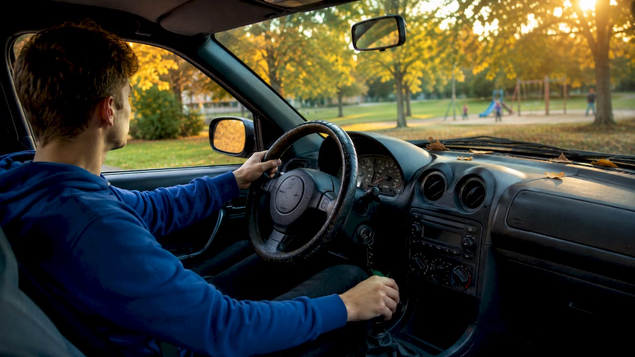 Hands operating clutch and gearshift in manual car