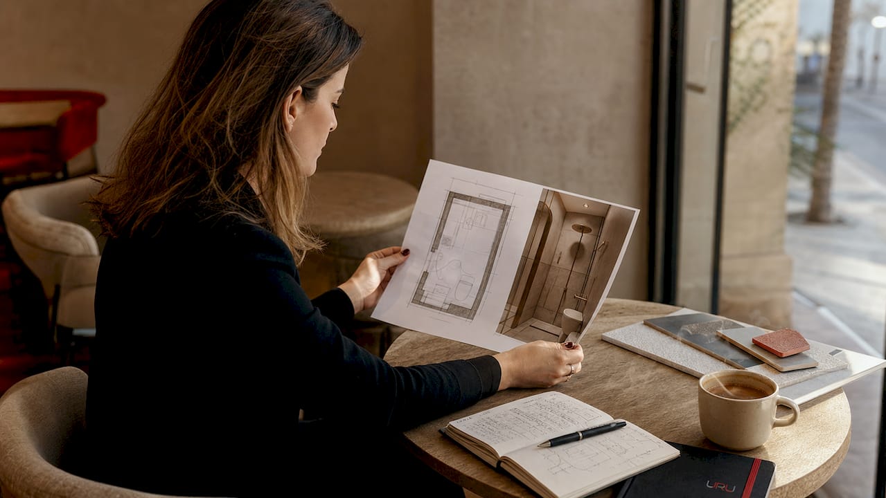 Arquitecta revisando los planos del baño en una vivienda