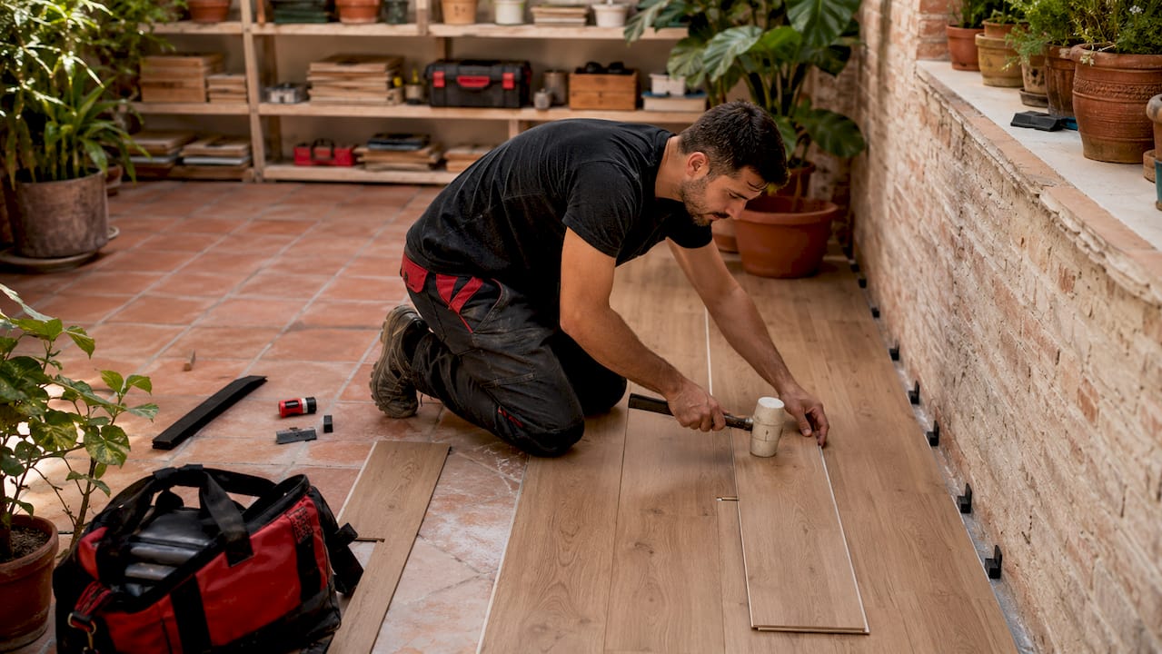 Profesional instalando suelo laminado en un salón de estilo moderno