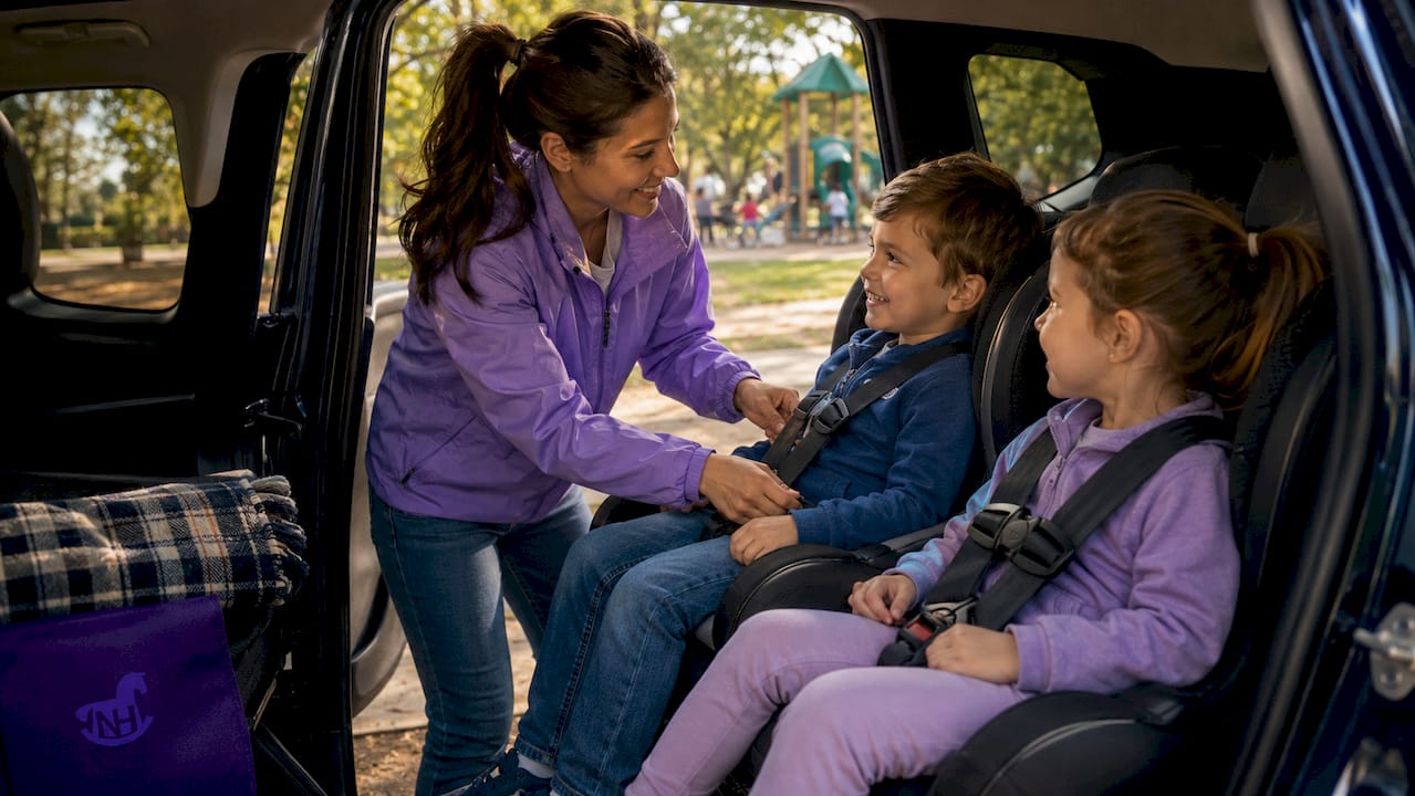 Nanny securing children in car seat