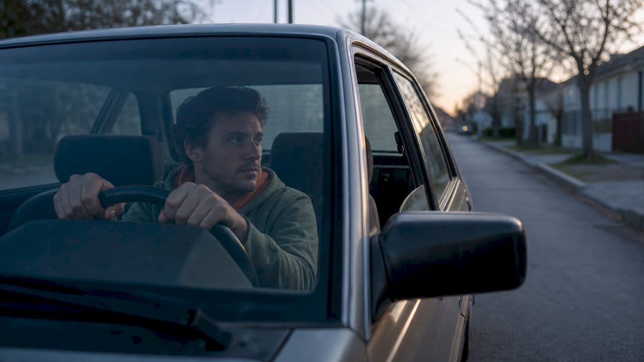 Man gripping steering wheel, looking distant