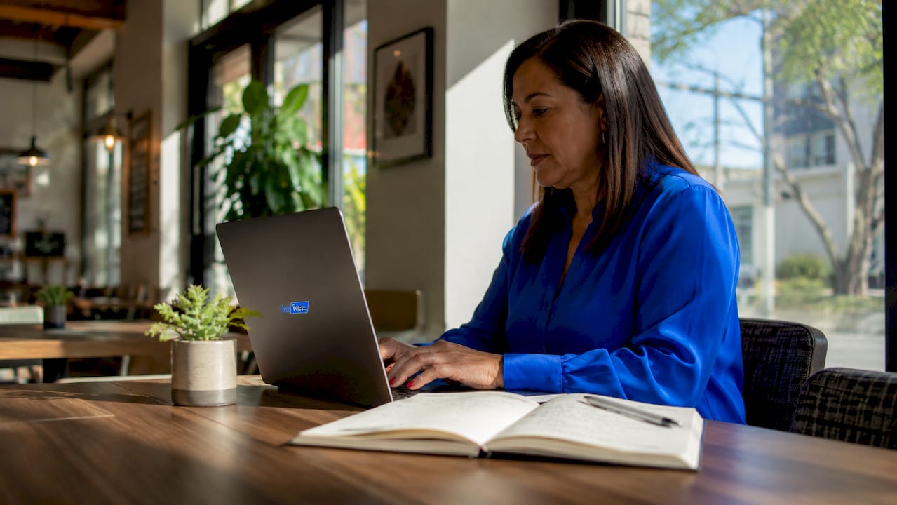 Una mujer revisa y estudia los datos de marketing de afiliados en su ordenador portátil.