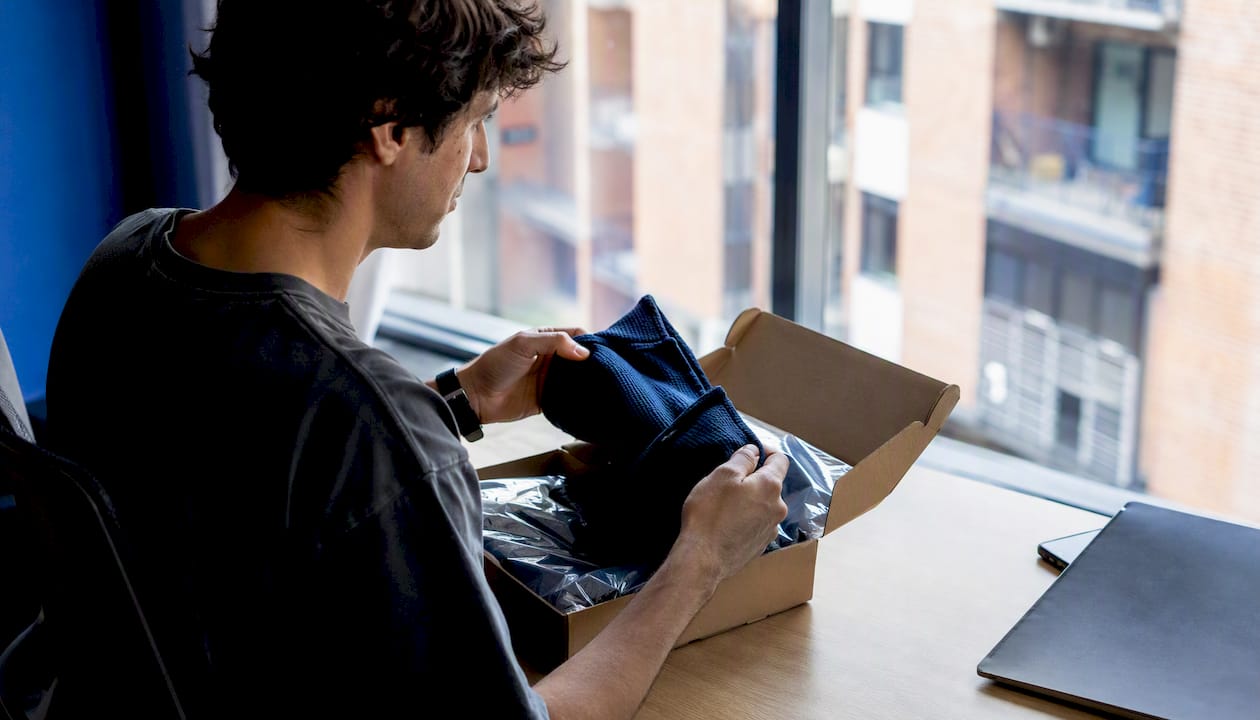 Manos abriendo cajas con muestras de moda