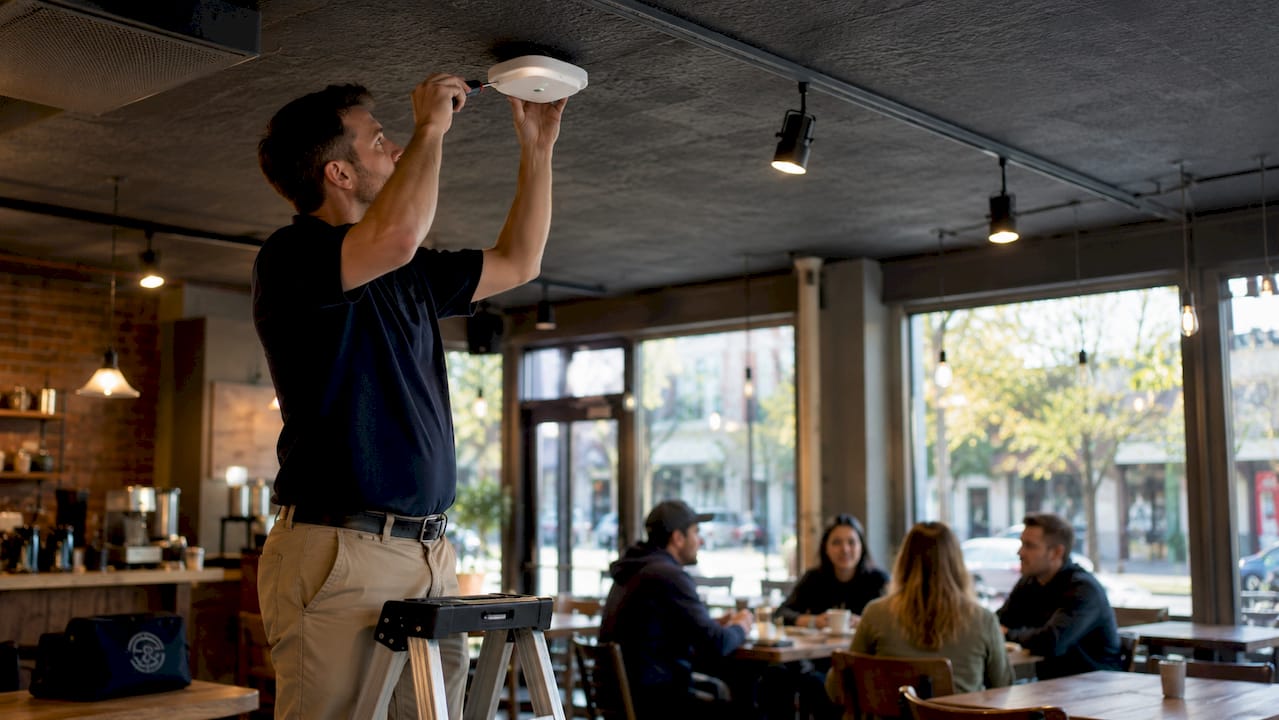 IT professional installing wifi access point on ceiling