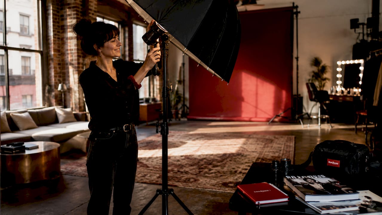 Photographer adjusting lighting in studio