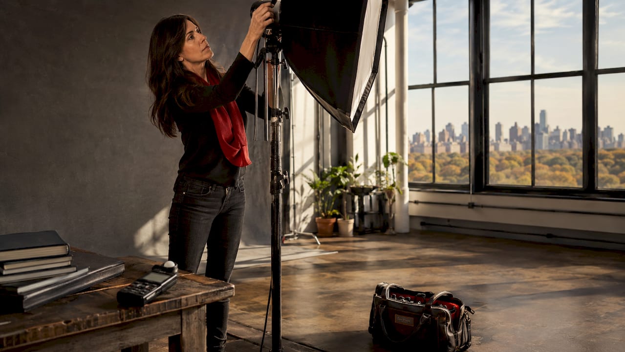 Photographer adjusting studio lighting in NYC studio