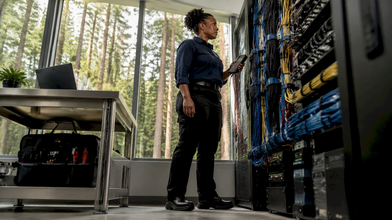 Engineer inspecting physical security cabling in control room