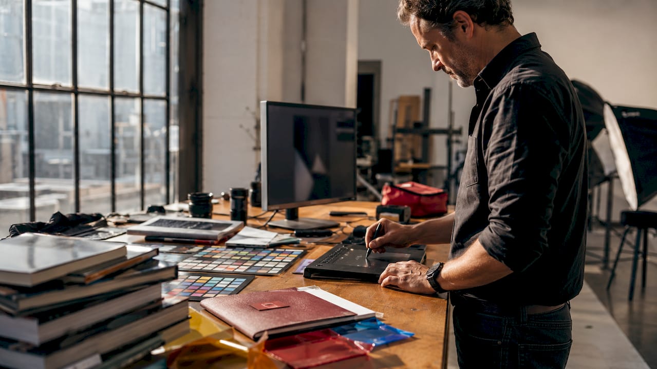 Photographer editing commercial photos in studio
