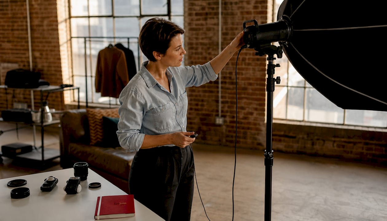 Photographer setting up strobe light in photo studio
