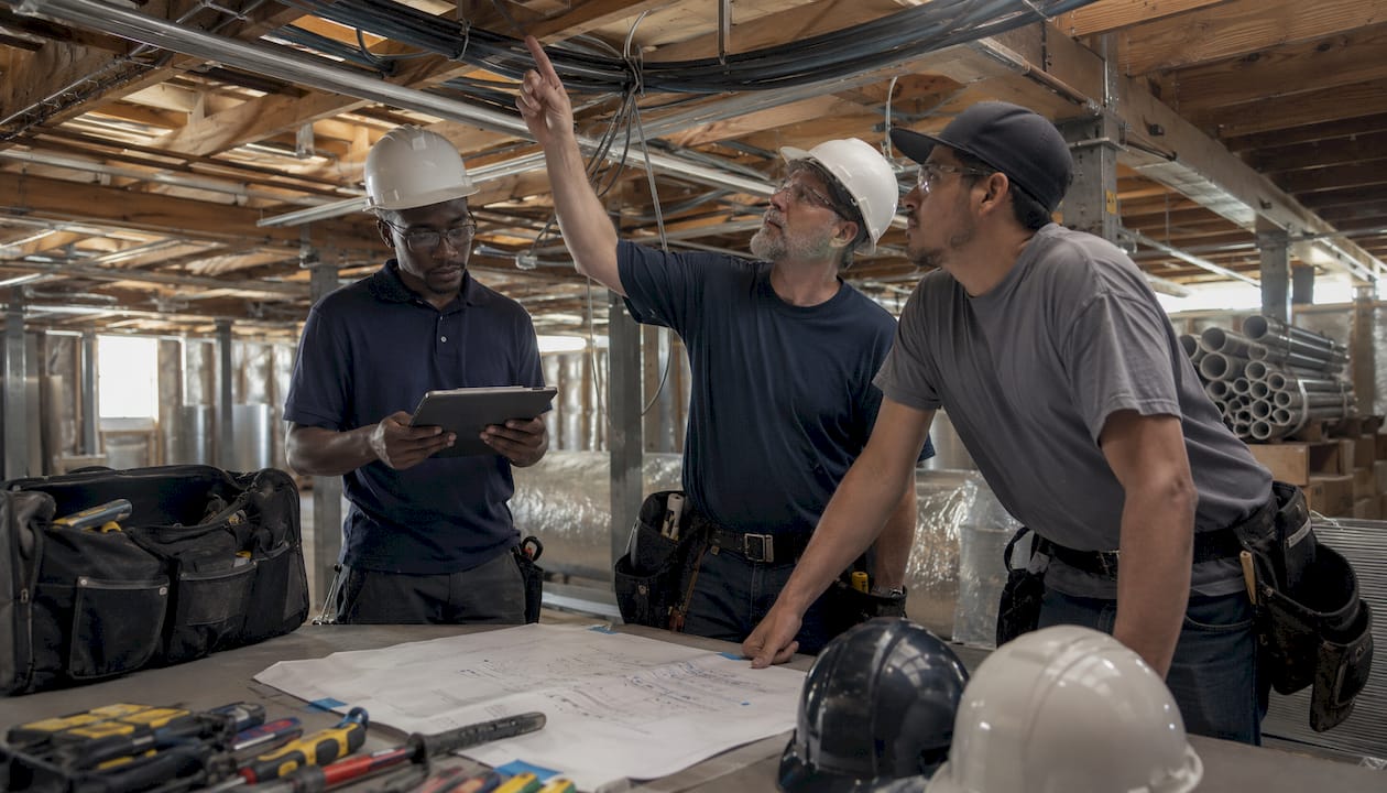 Tradespeople coordinating low voltage installation in ceiling