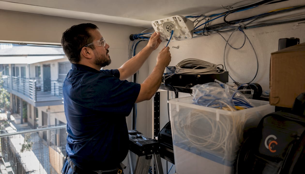 IT engineer installing Wi-Fi access point cabling