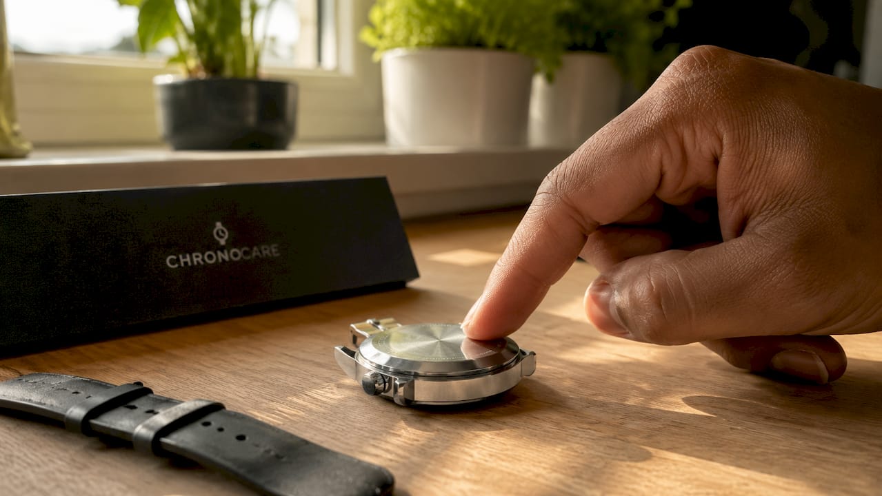 Hand performing fingernail test on watch scratch