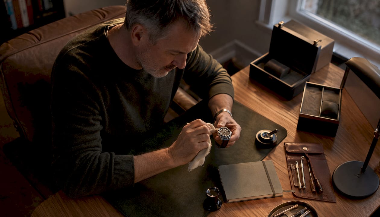 Collector polishing luxury watch at workshop bench