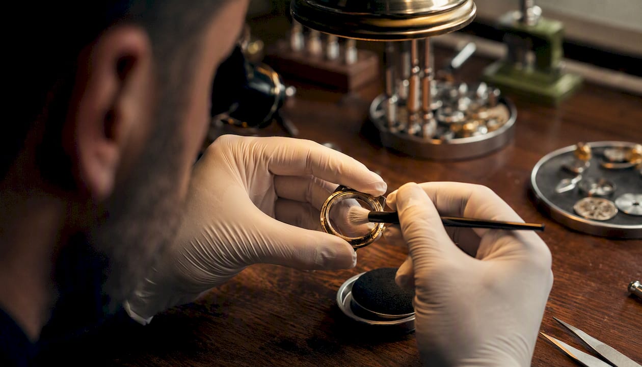Watchmaker using brush in cleaning demo