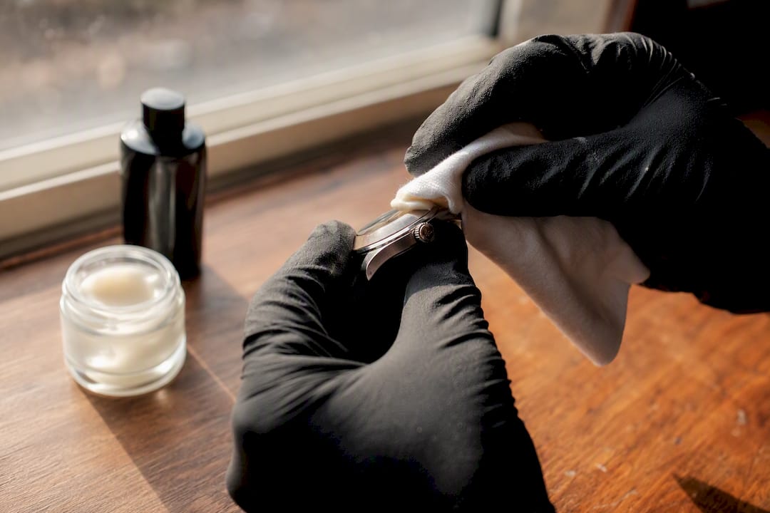 Gloved hand applying watch polishing cream