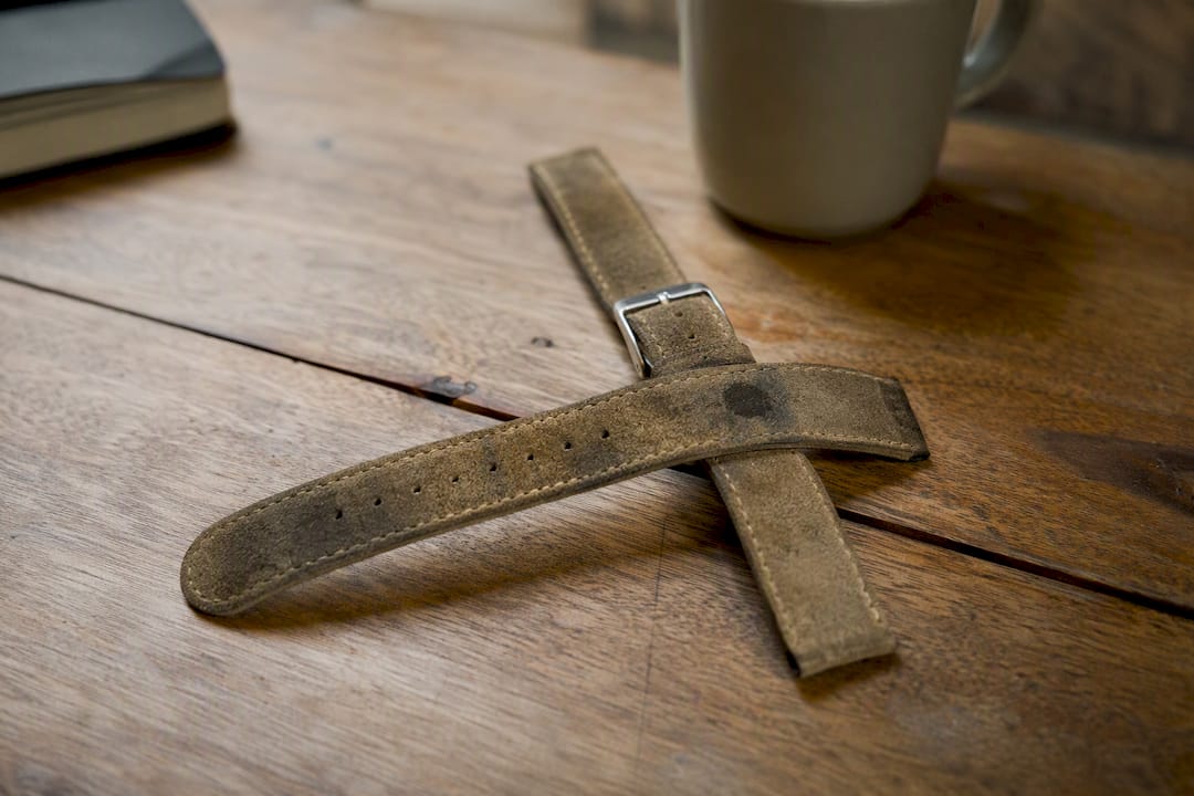 Close-up of worn stained suede watch strap