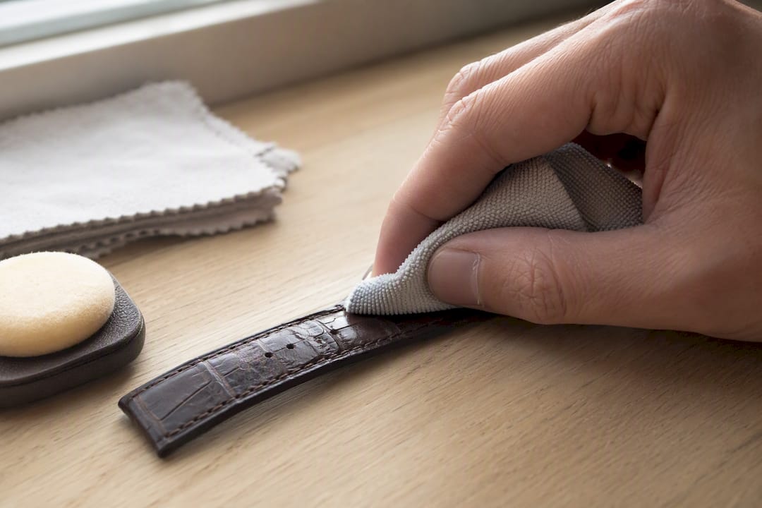 Hand wiping leather watch strap with microfiber cloth