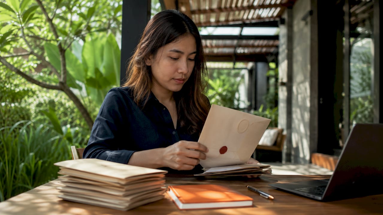 Hands sorting compliance permit documents on desk