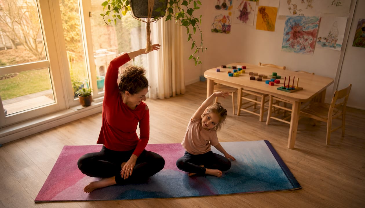 Een moeder begeleidt haar kind bij de fysiotherapie-oefeningen thuis.