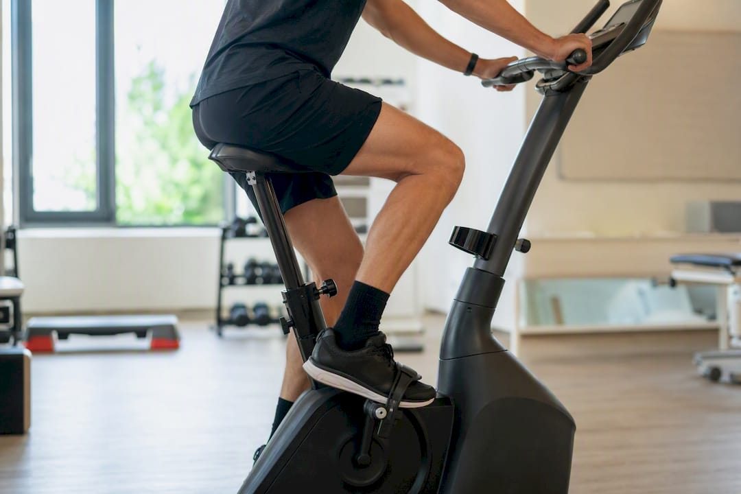 Patiënt fietst op hometrainer voor revalidatie