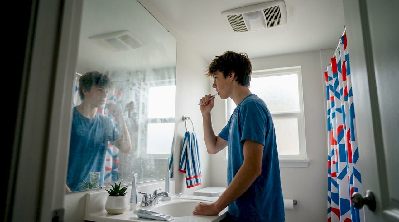 Teen using bathroom with active exhaust ventilation