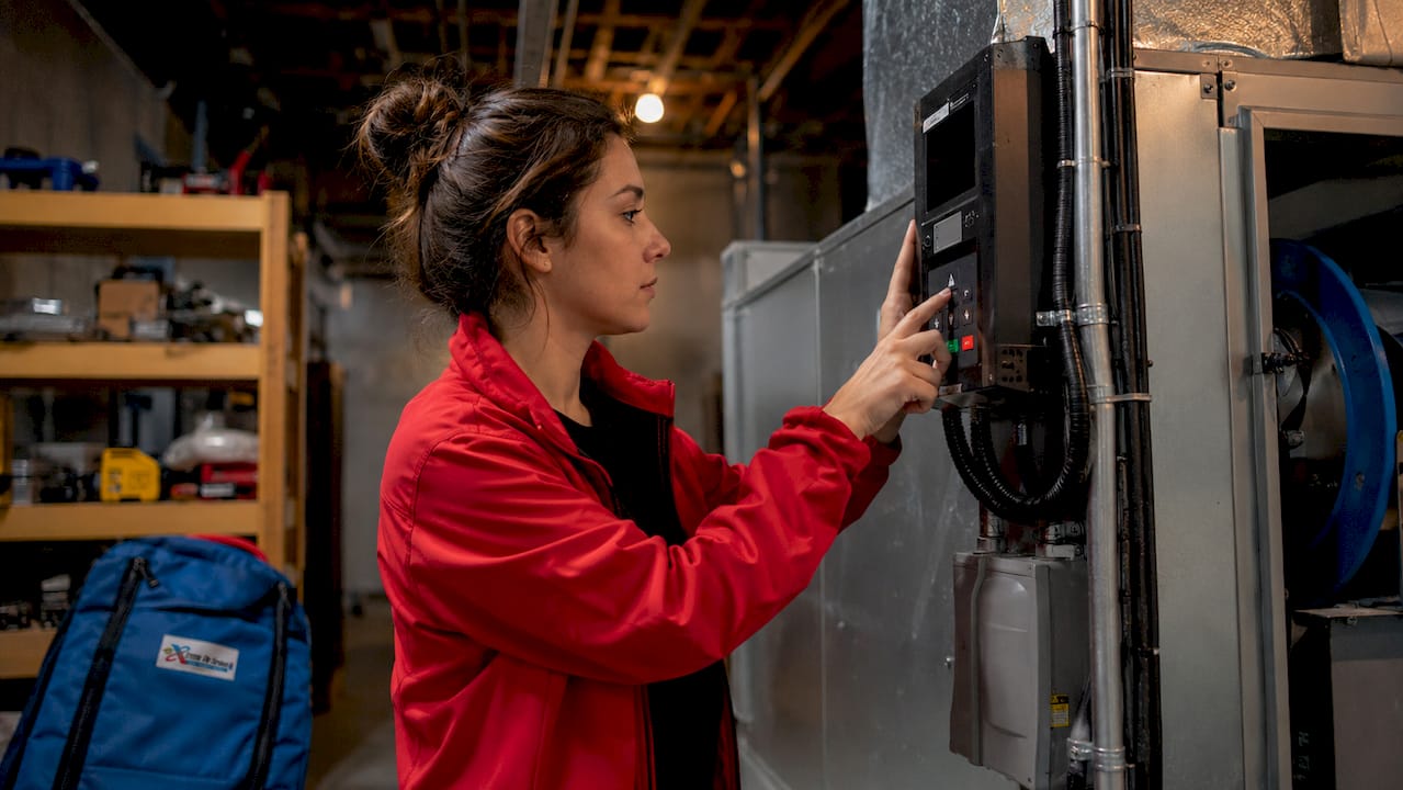 Hands adjusting VFD on air handling unit