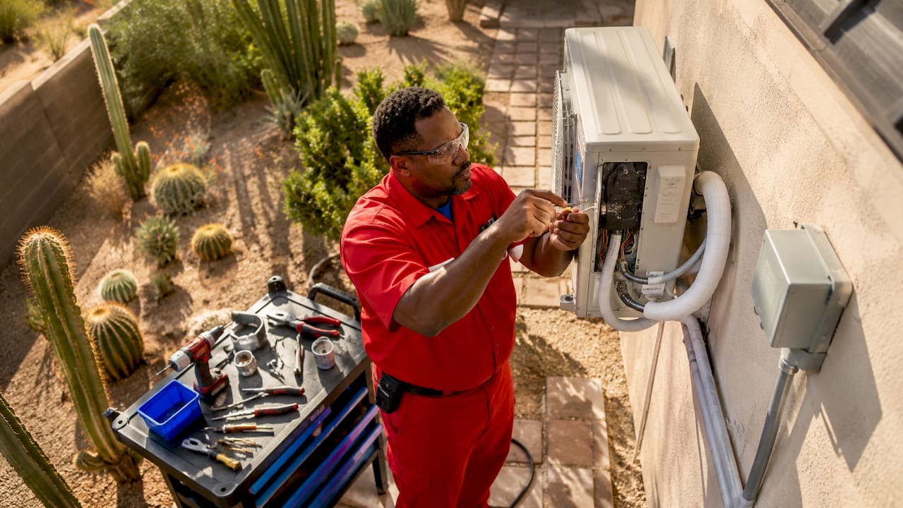 Technician installing heat pump at Phoenix home