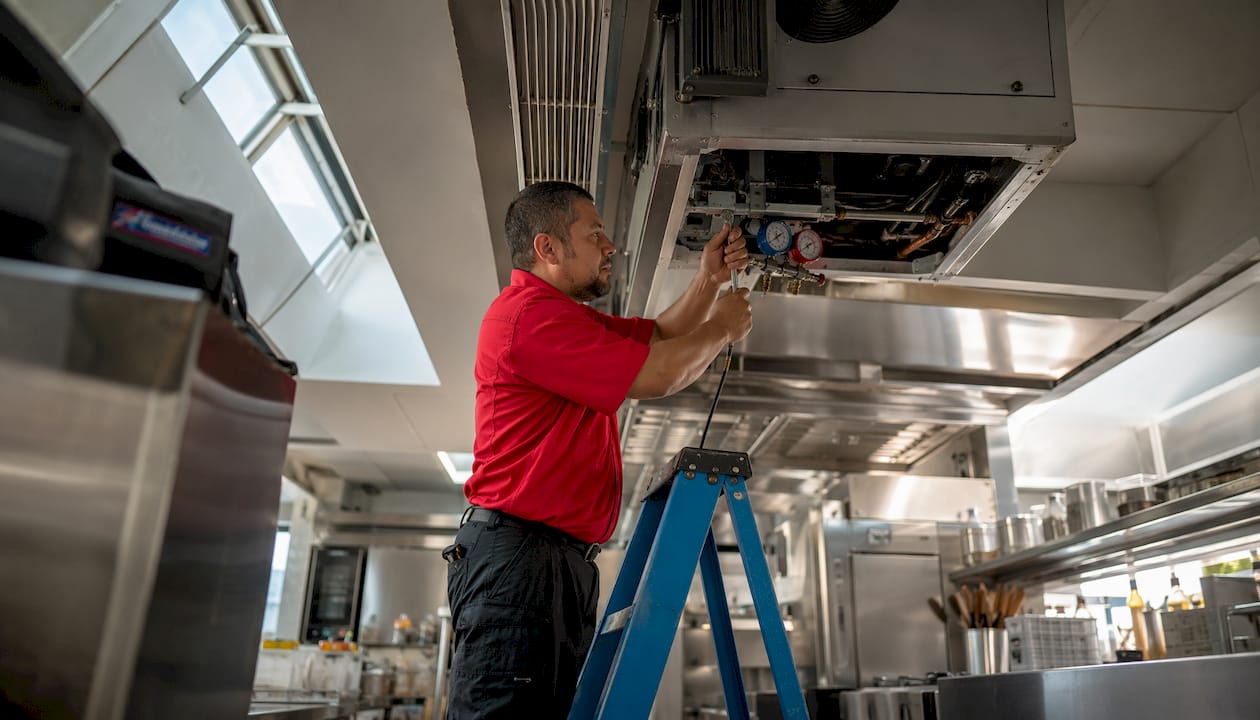 Technician maintaining commercial HVAC system