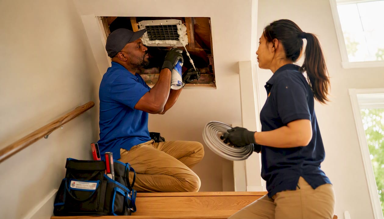 Electricians sealing attic air leaks