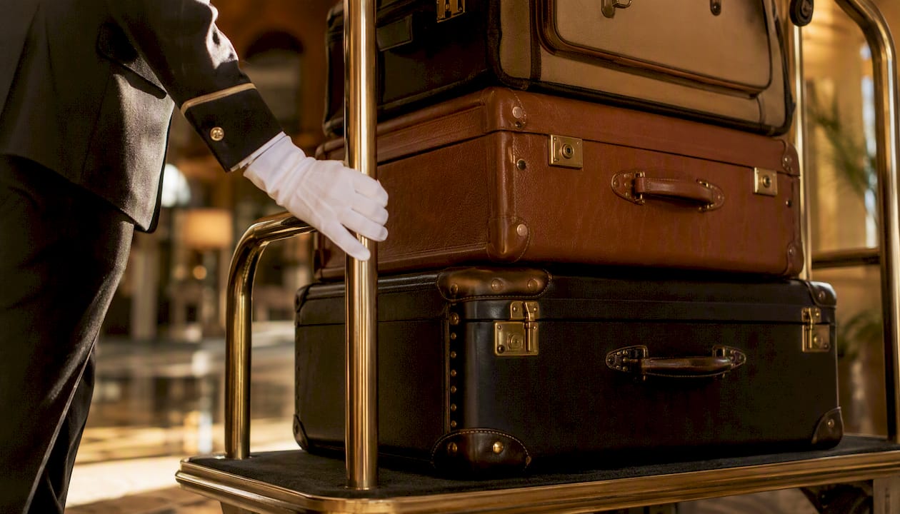 Hotel concierge handling luxury luggage cart