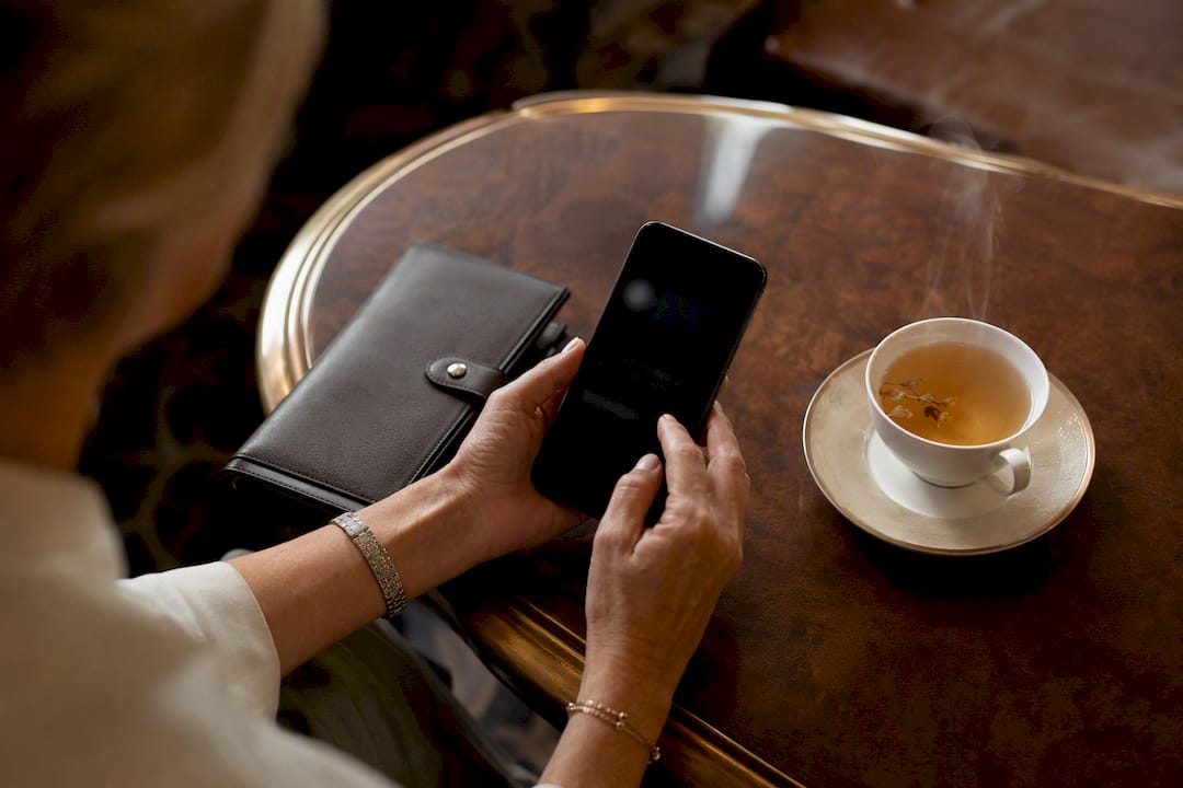 Hands holding smartphone in travel agency