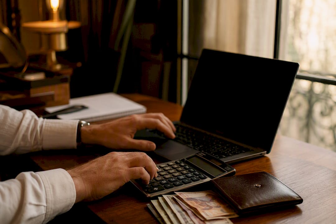 Hands calculating travel budget at elegant desk