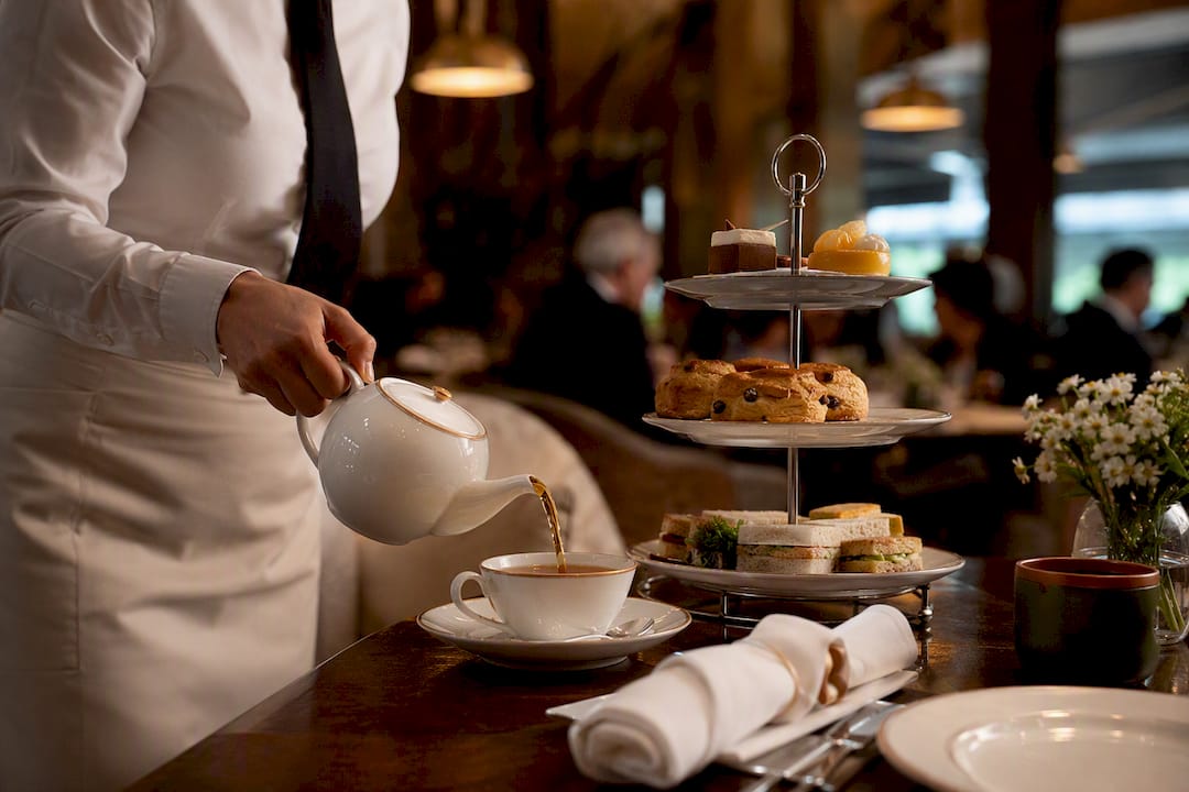 Server pouring tea in hospitality lounge