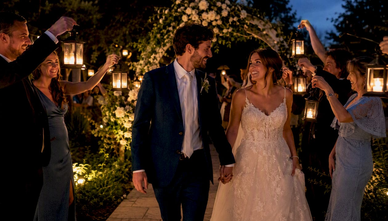 Couple leaving wedding with guest sparkler tunnel